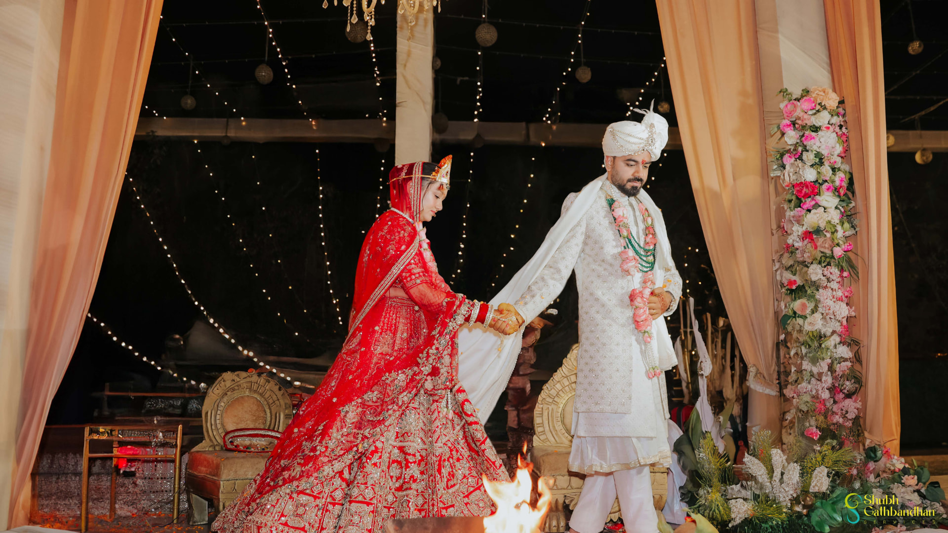 The couple walking the pheras around the fire inside the mandap