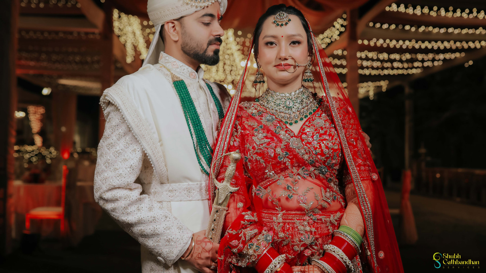 The couple in a quiet portrait framed by fairy lights and jasmine strings