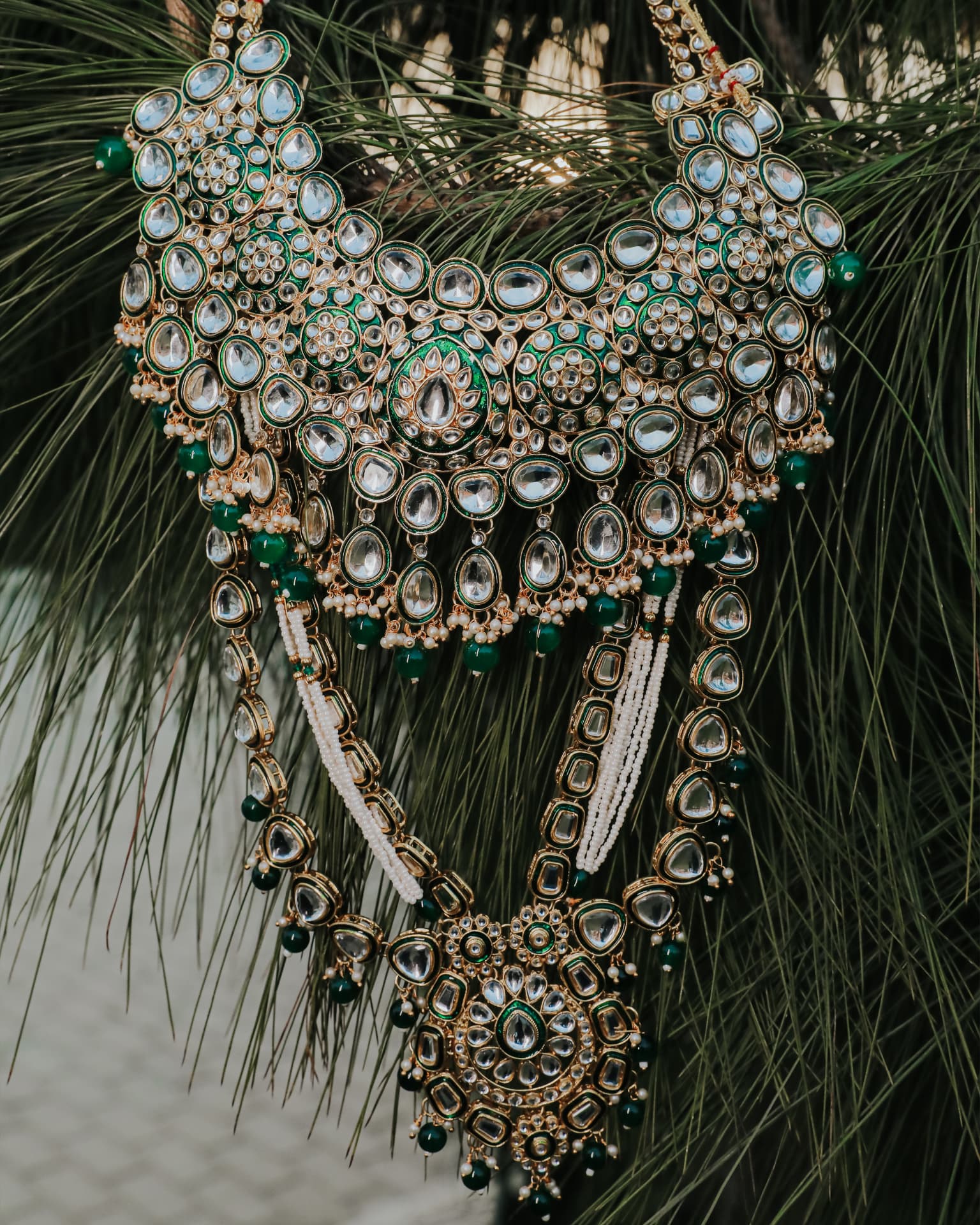 The bridal kundan necklace set hung among pine needles