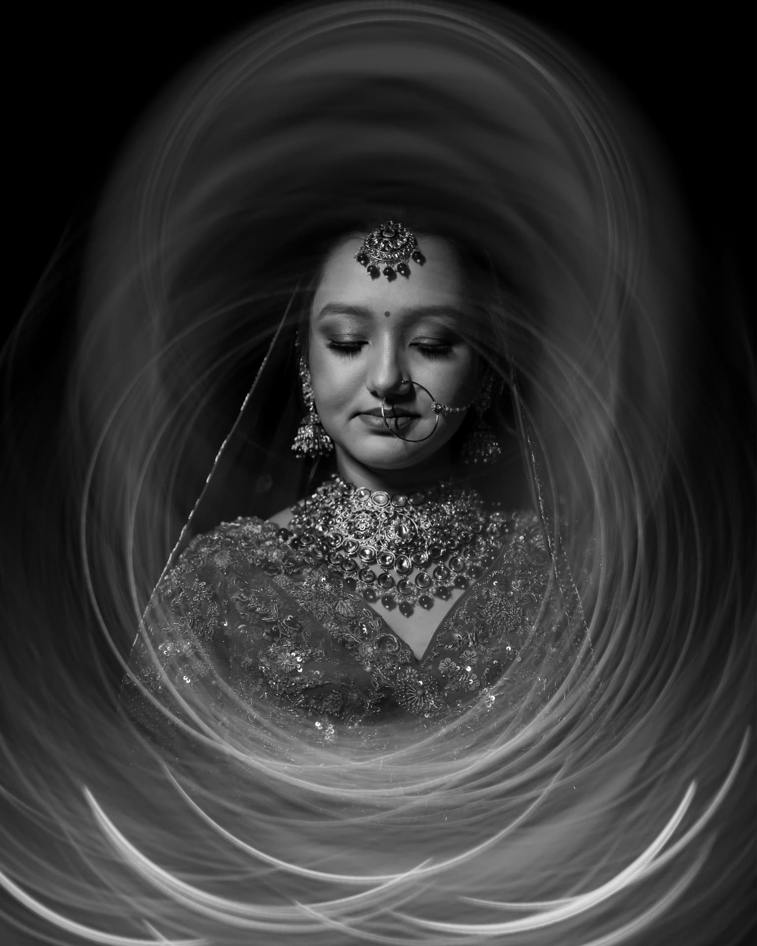 Black and white long-exposure portrait of Soumya with her veil in motion